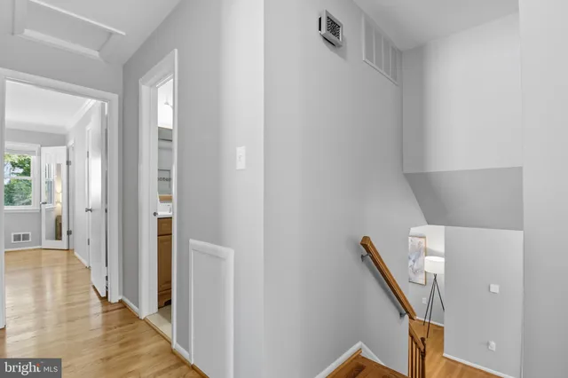 a view of a hallway with wooden floor and staircase