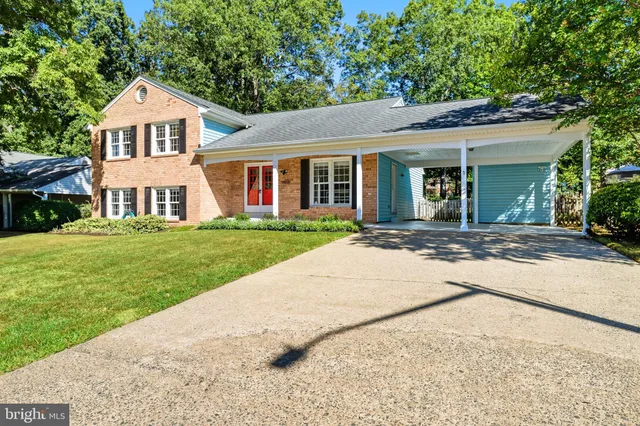 a front view of a house with a yard and trees