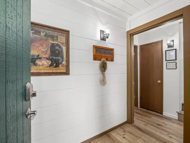 a bedroom with a bed a dresser and next to a window