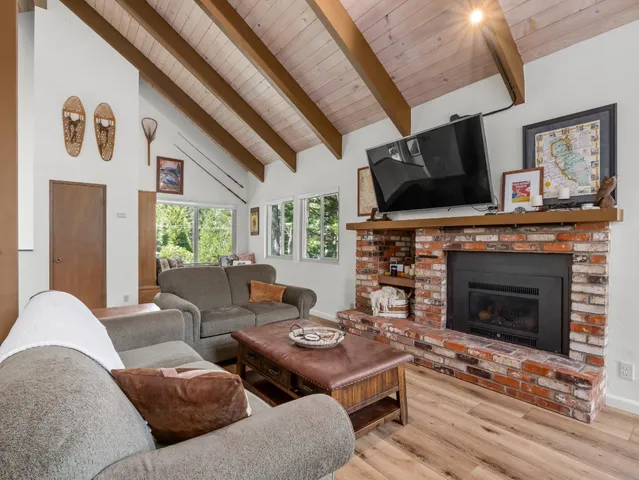 a kitchen with stainless steel appliances granite countertop a refrigerator a microwave oven a dining table and chairs with wooden floor