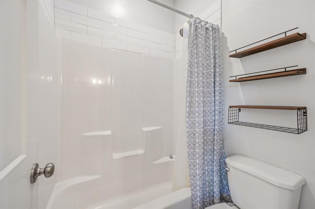 745 North Miller Avenue Stephenville, TX 76401 - Photo 26 of 31 White subway tile accents a bright tub and shower combination