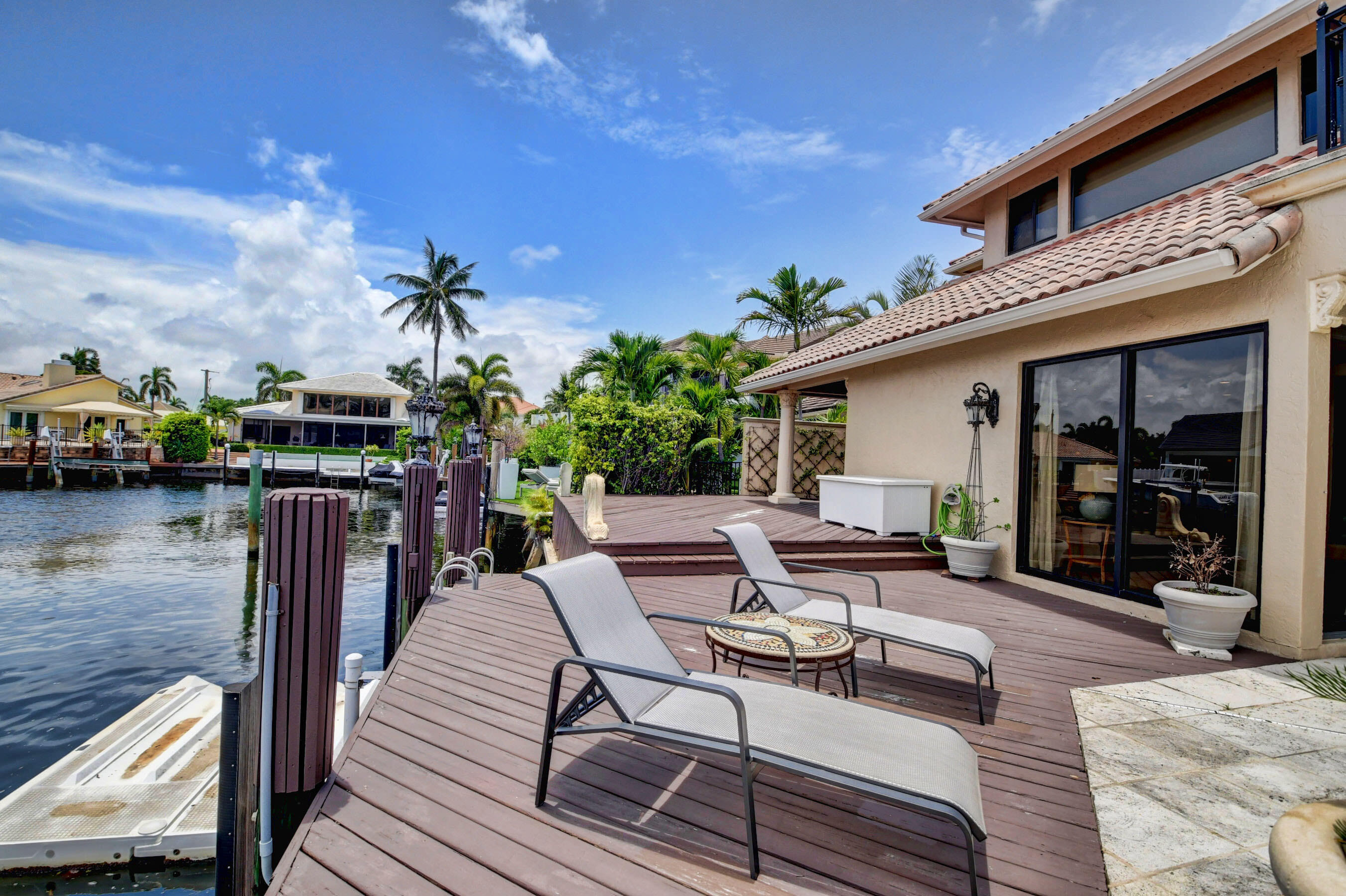 860 Northeast 79th Street Boca Raton, FL 33487 - Photo 106 of 109 a roof deck with table and chairs a barbeque with wooden floor and fence
