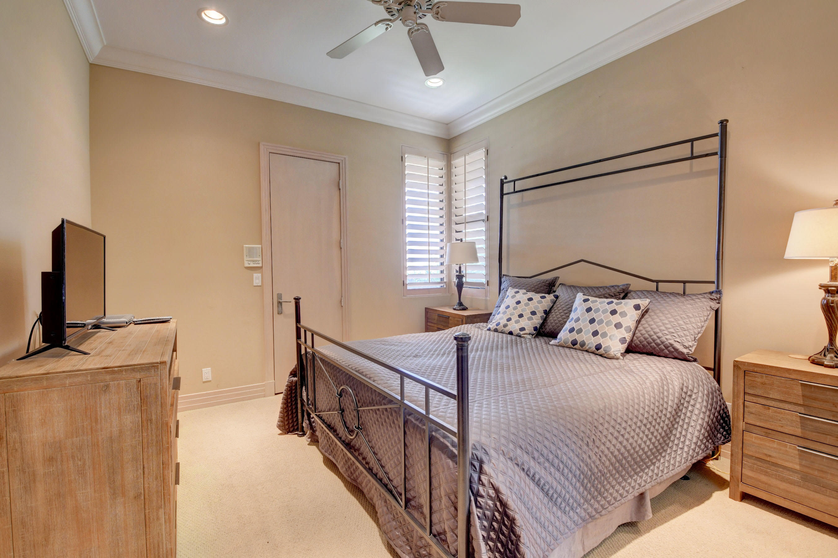 860 Northeast 79th Street Boca Raton, FL 33487 - Photo 40 of 109 a bedroom with a bed a chandelier and a flat tv
