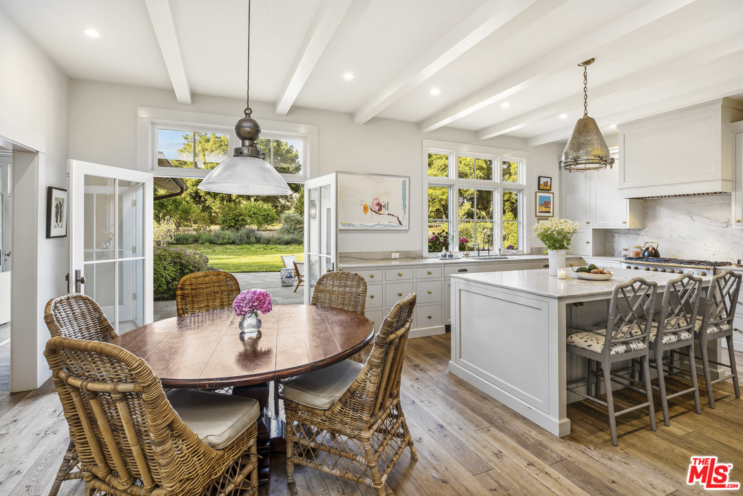 4646 Via Roblada Santa Barbara, CA 93110 - Photo 13 of 36 a kitchen with a dining table chairs and chandelier