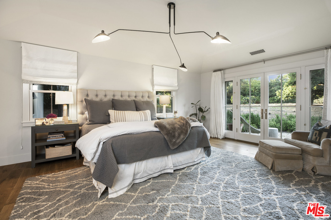 4646 Via Roblada Santa Barbara, CA 93110 - Photo 22 of 36 a spacious bedroom with a bed and glass window