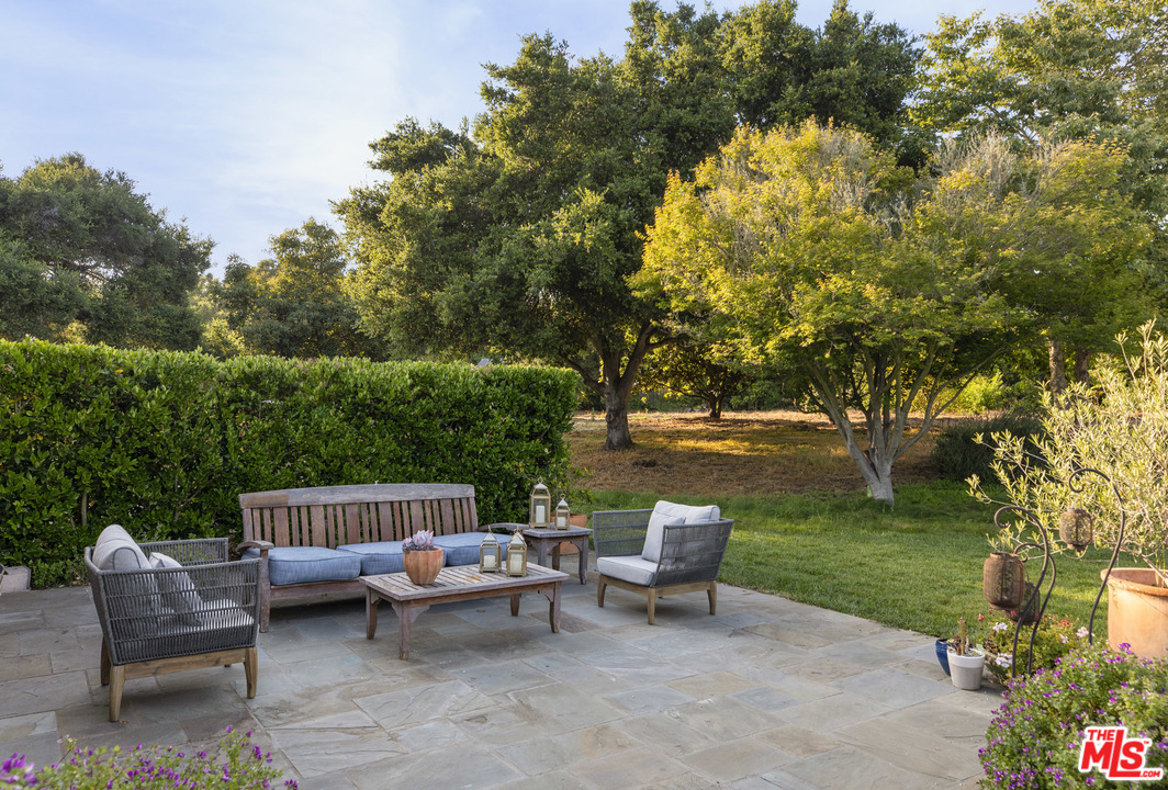 4646 Via Roblada Santa Barbara, CA 93110 - Photo 24 of 36 a view of a patio with a table and chairs potted plants and a large tree