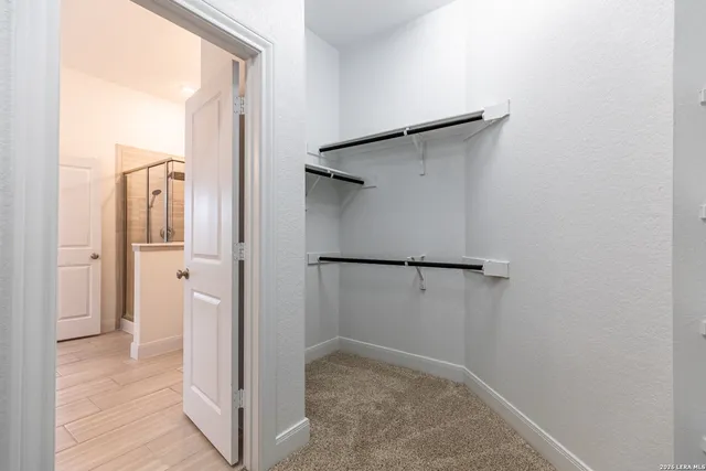 a view of walk in closet with empty racks
