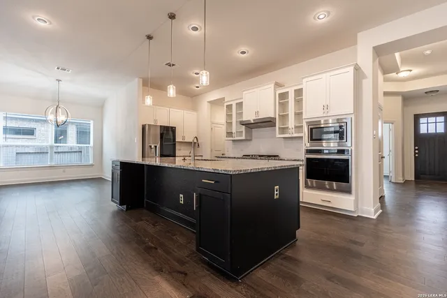 a kitchen with a sink cabinets and wooden floor
