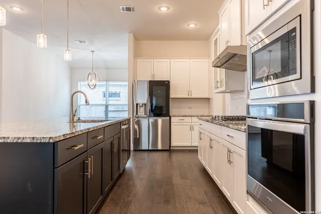 a kitchen with granite countertop a sink and cabinets