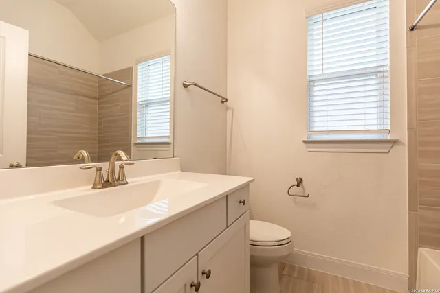 a bathroom with a sink a toilet and a mirror