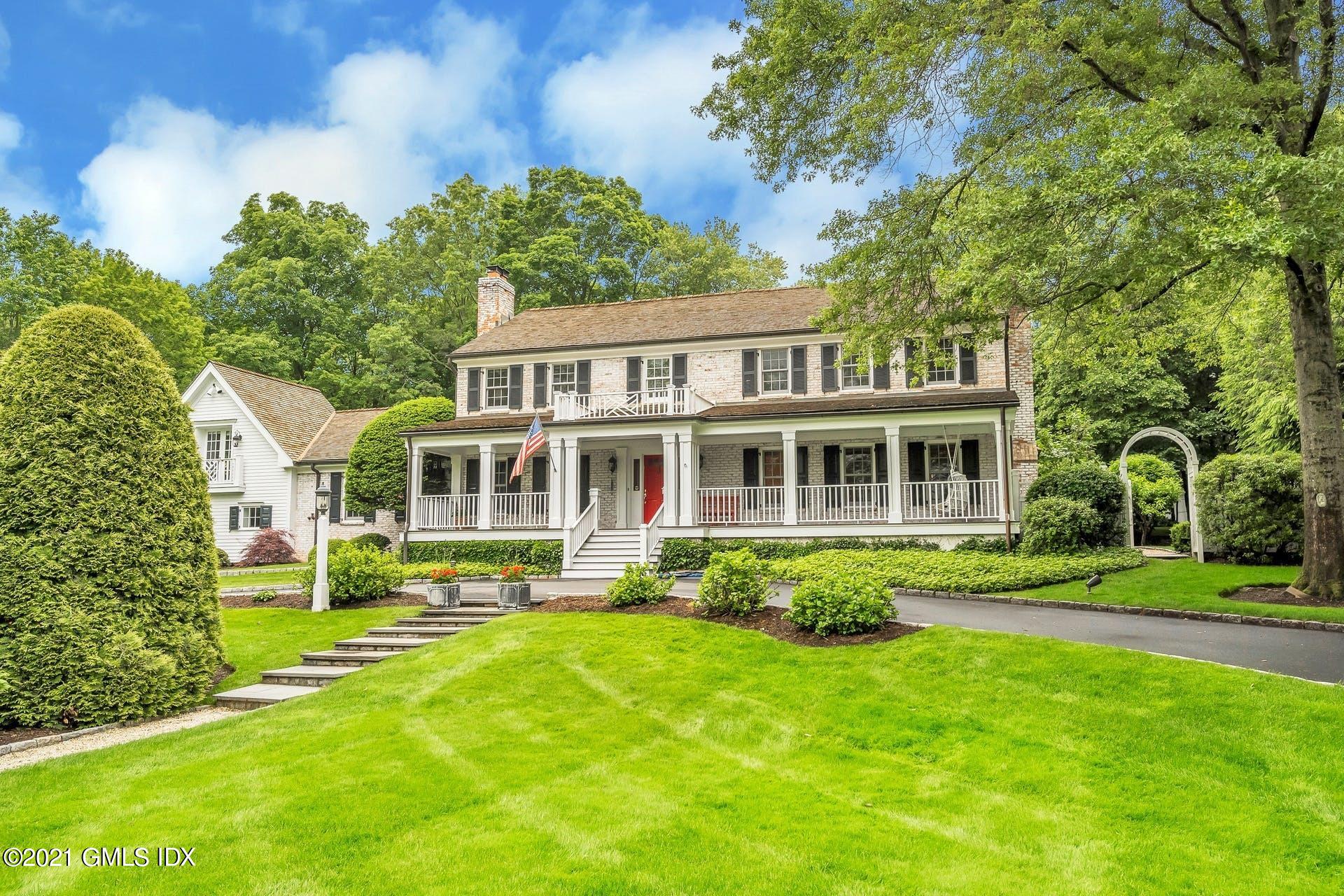 425 Stanwich Road Greenwich, CT 06830 - Photo 2 of 36 a front view of a house with a yard table and chairs