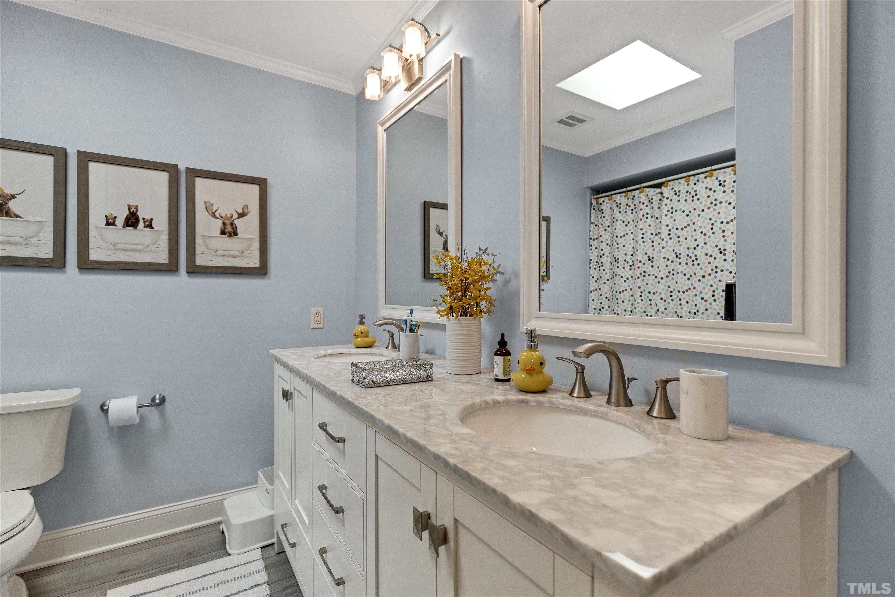 6813 Foxfire Place Raleigh, NC 27615 - Photo 18 of 34 a bathroom with a sink vanity and a toilet