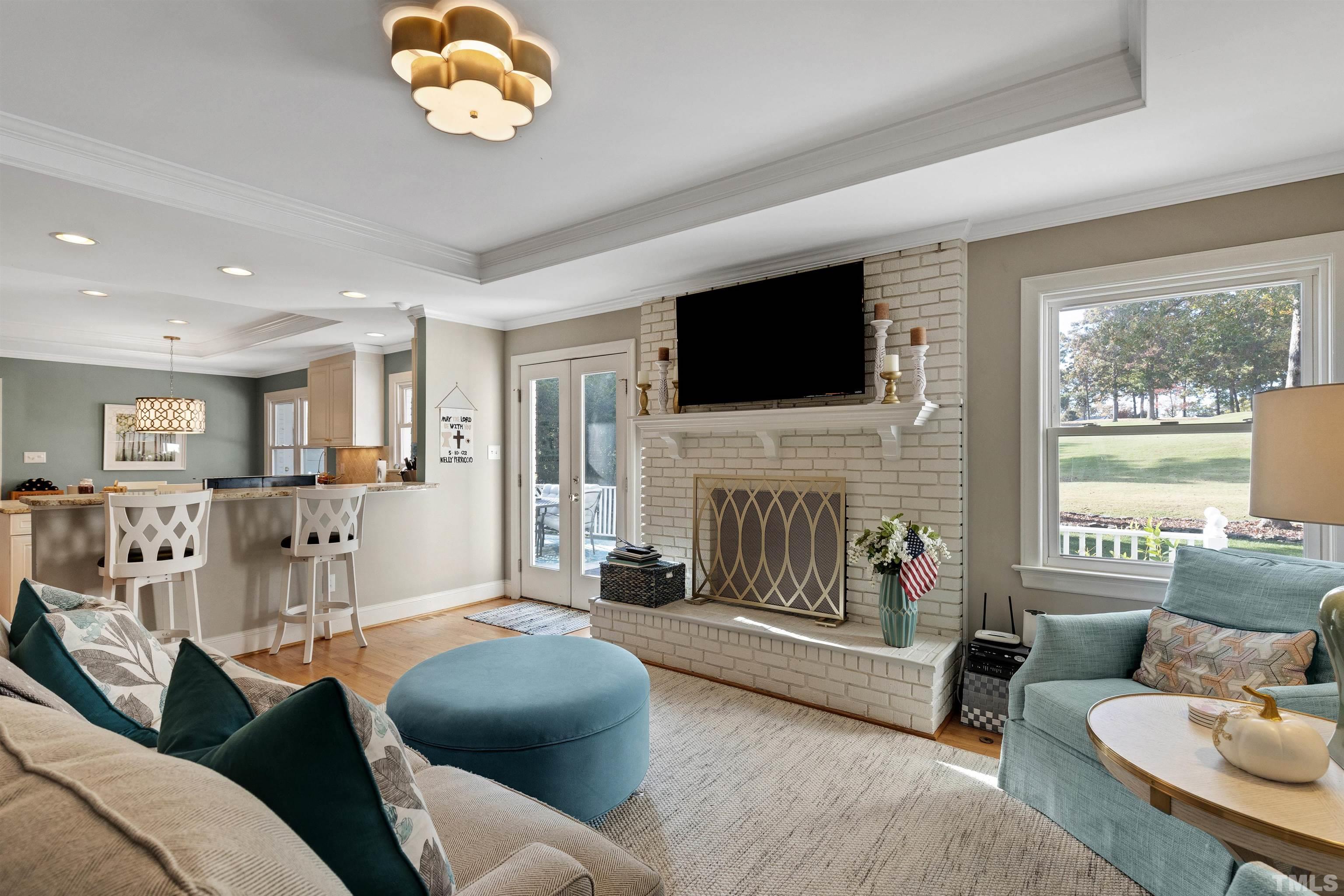 6813 Foxfire Place Raleigh, NC 27615 - Photo 25 of 34 a living room with furniture a fireplace and a flat screen tv