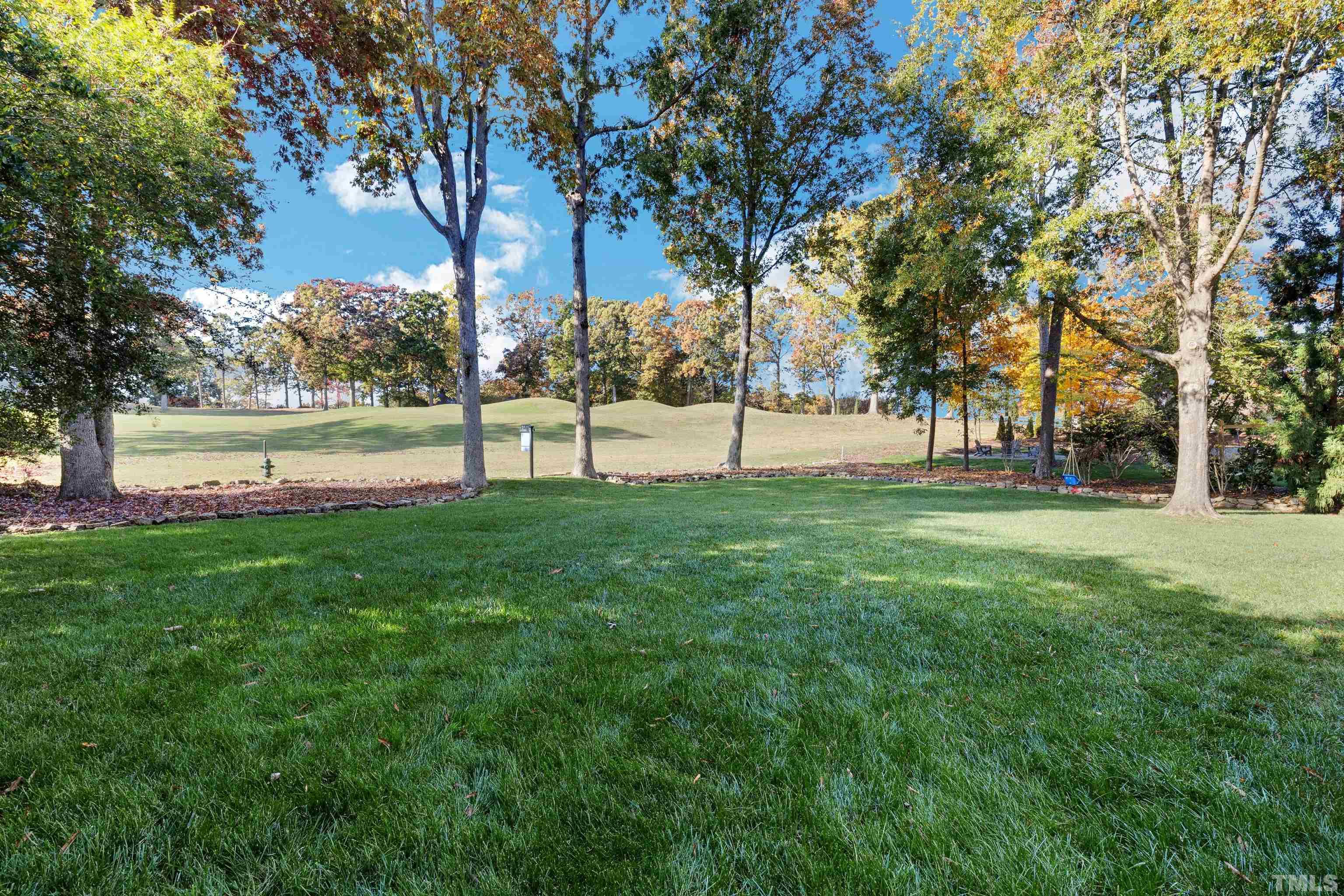 6813 Foxfire Place Raleigh, NC 27615 - Photo 33 of 34 a view of green field with trees in the background