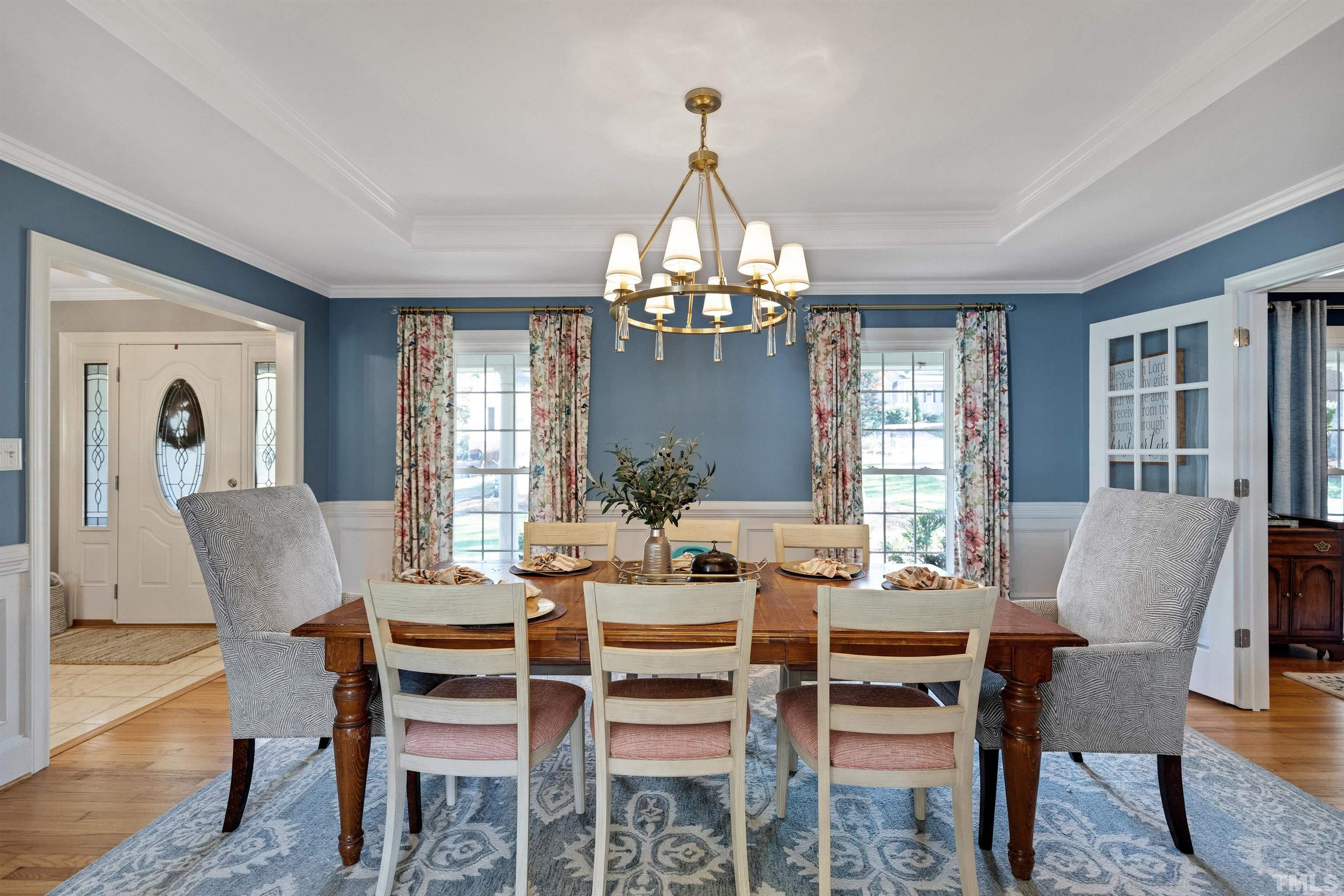 6813 Foxfire Place Raleigh, NC 27615 - Photo 5 of 34 a dining room with furniture a chandelier and wooden floor