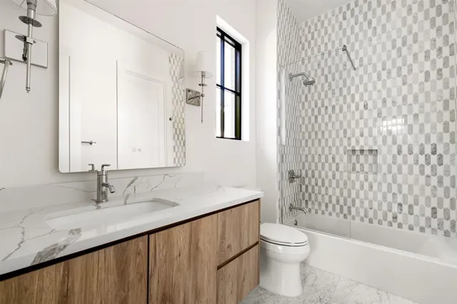 a bathroom with a granite countertop sink toilet and shower