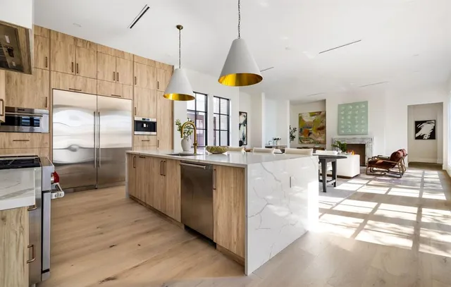 a kitchen with stainless steel appliances kitchen island granite countertop a stove a sink a refrigerator and a refrigerator