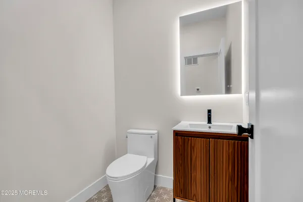 a bathroom with a toilet a sink and mirror