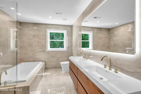 a bathroom with double vanity sinks and a bathtub