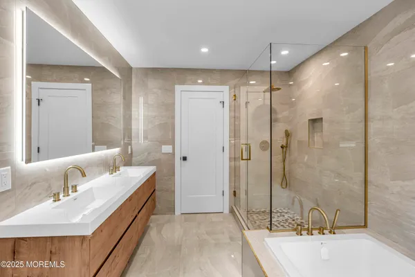 a bathroom with a tub sink and mirror