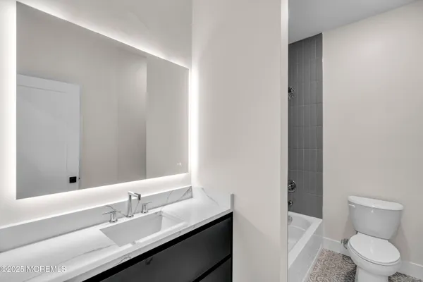 a bathroom with a sink a toilet a shower and a mirror