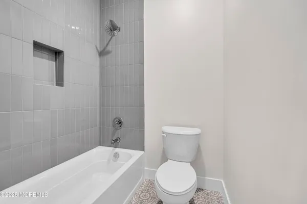 a white toilet sitting next to a bath tub