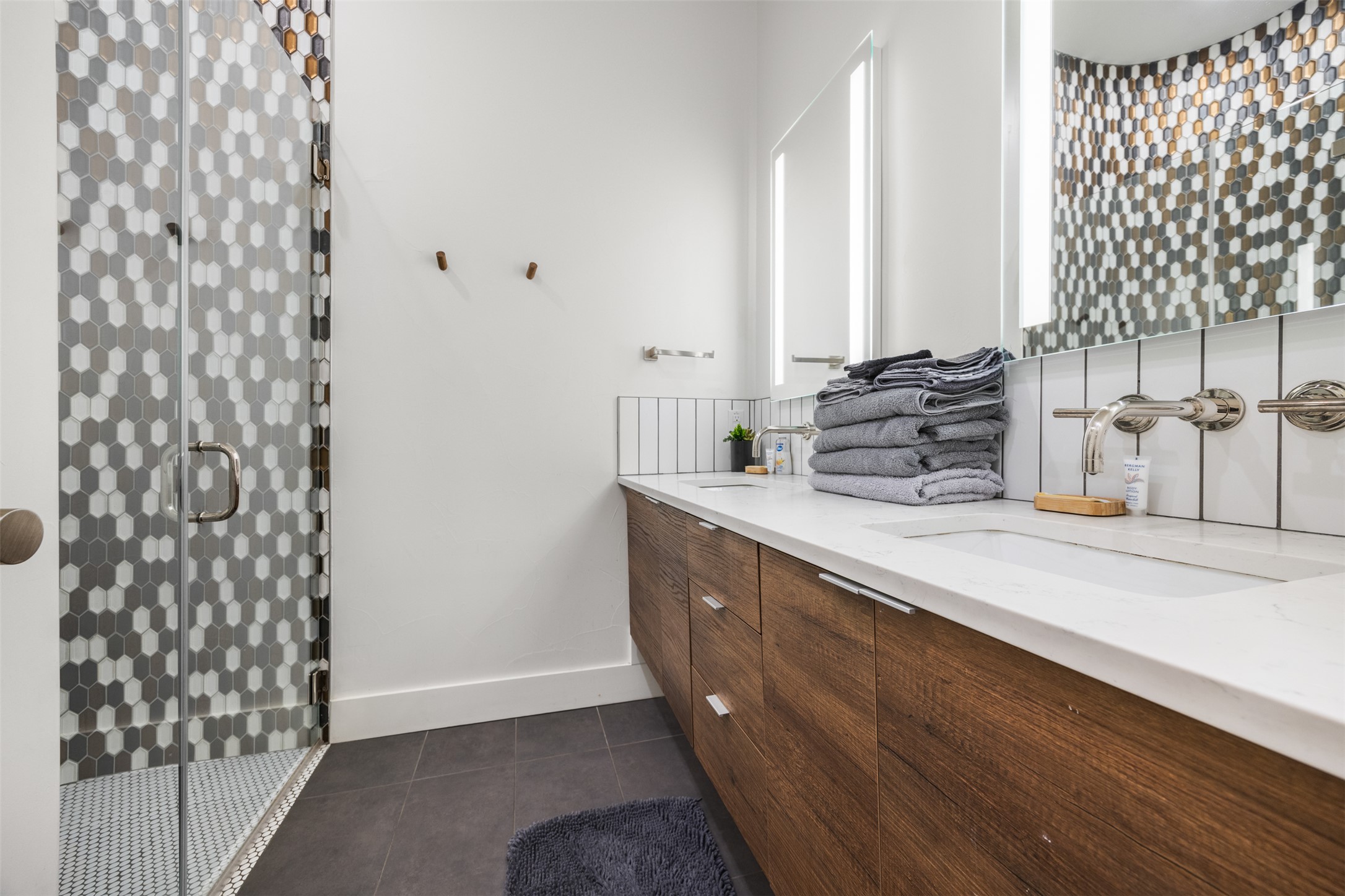 4103 Ridgelea Drive Austin, TX 78731 - Photo 21 of 26 A sleek bathroom vanity with double sinks, complemented by a mosaic-tiled shower for a modern aesthetic.