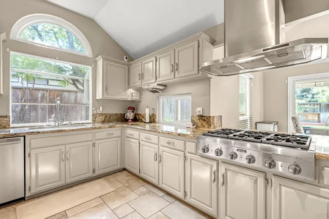 a kitchen with stainless steel appliances a sink stove and cabinets
