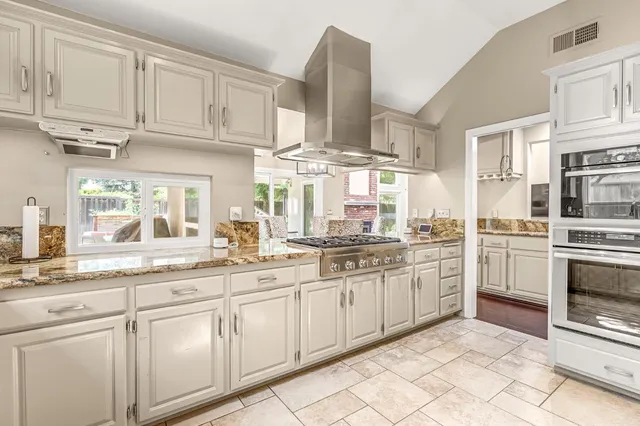 a kitchen with stainless steel appliances granite countertop a sink and cabinets
