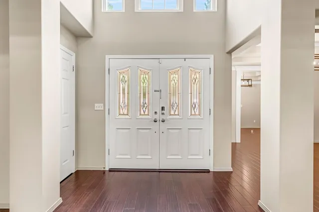an empty room with wooden floor and mirror