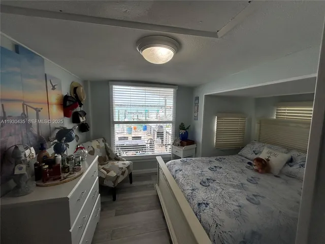 a bedroom with a bed and a view of living room