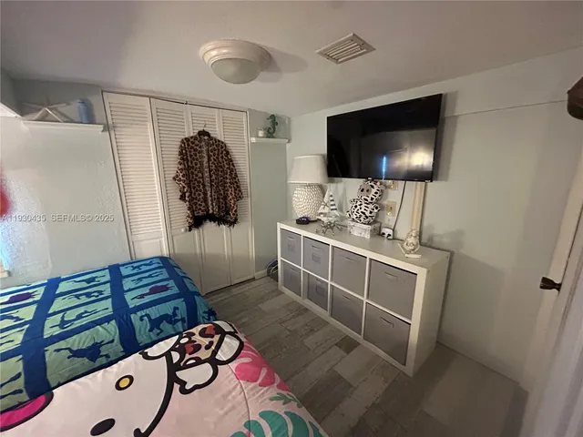 a bedroom with two beds with a baby crib