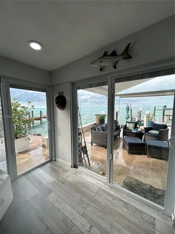 a living room with patio furniture and a large window