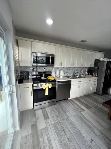 a living room with furniture and kitchen