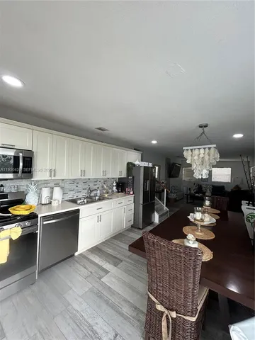 a view of a dining room with furniture a chandelier and wooden floor