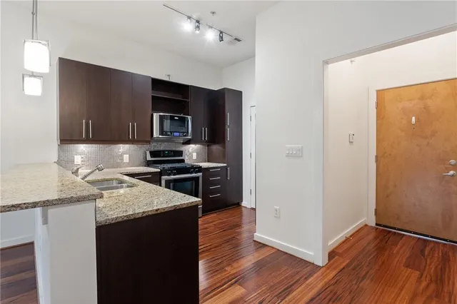 a kitchen with granite countertop stainless steel appliances and wooden cabinets