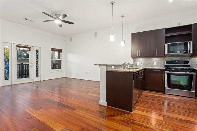 a kitchen with stainless steel appliances granite countertop a stove a sink and a microwave