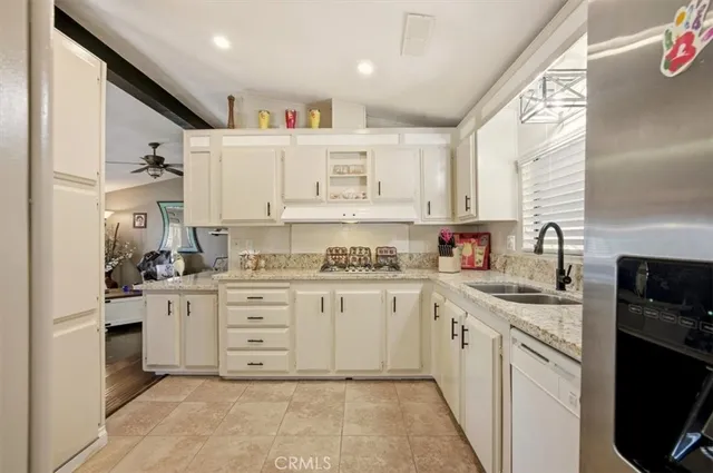 a kitchen with stainless steel appliances a refrigerator sink and cabinets