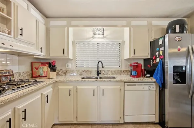 a kitchen with granite countertop white cabinets and white appliances
