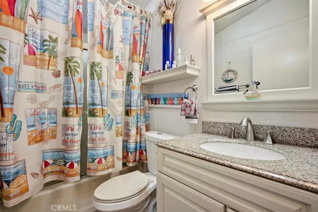 a bathroom with a granite countertop sink a mirror and shower