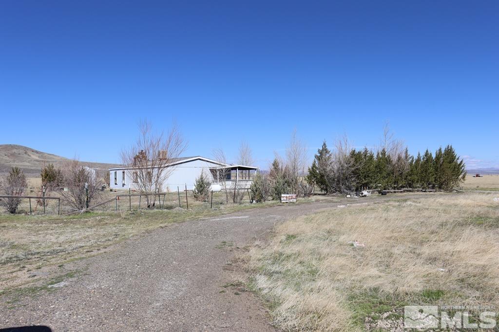 a view of dirt yard with a house