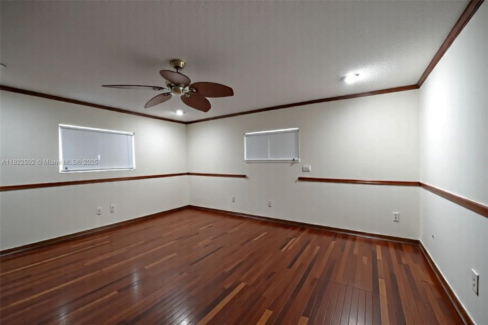 22115 Southwest 58th Avenue Boca Raton, FL 33428 - Photo 14 of 18 a view of an empty room with wooden floor and a ceiling fan