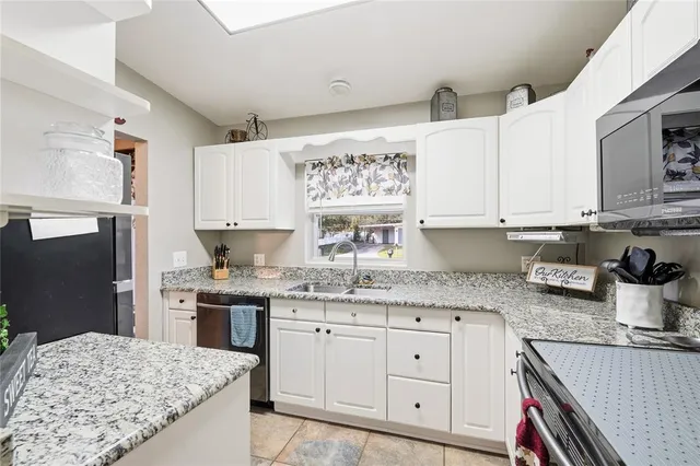a kitchen with stainless steel appliances granite countertop a sink and a stove