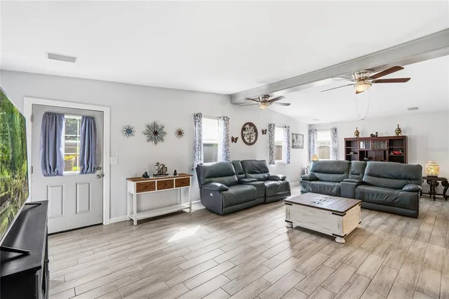 a living room with furniture and a wooden floor