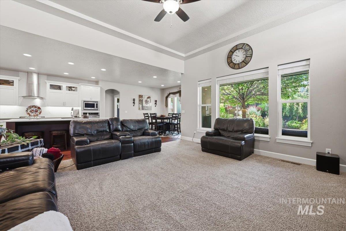 1303 West Brando Street Meridian, ID 83646 - Photo 20 of 49 Open-concept living space featuring a spacious carpeted area, large windows, recessed lighting, and a ceiling fan