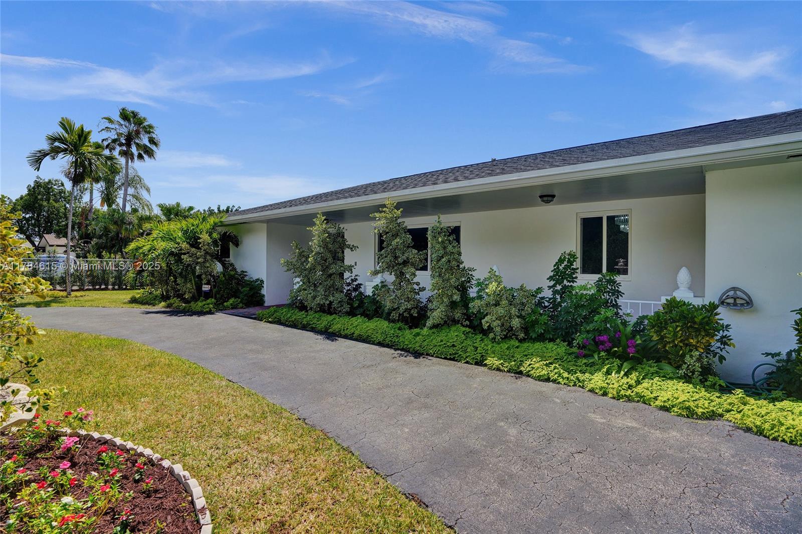 7360 Southwest 120th Street Pinecrest, FL 33156 - Photo 15 of 68 a front view of a house with garden