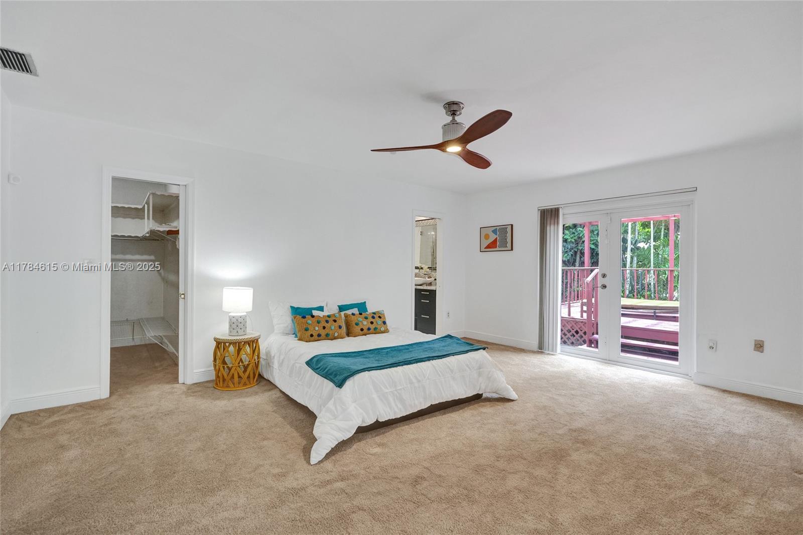 7360 Southwest 120th Street Pinecrest, FL 33156 - Photo 26 of 68 a bedroom with a bed and a chandelier