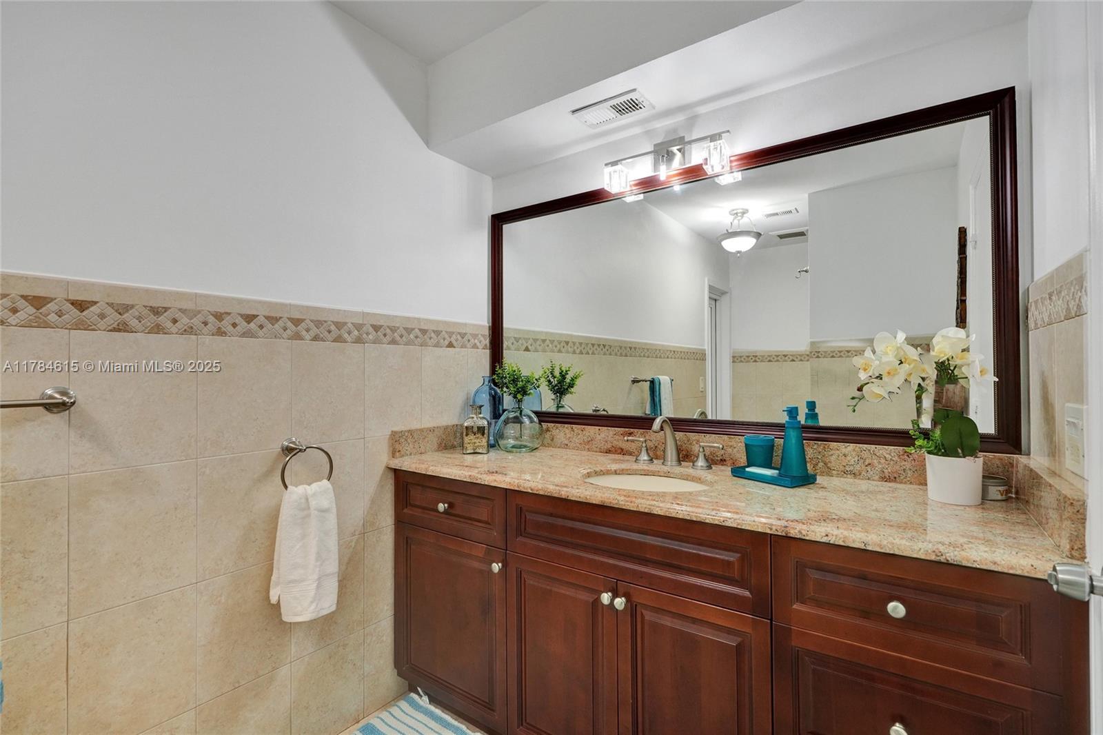 7360 Southwest 120th Street Pinecrest, FL 33156 - Photo 40 of 68 a bathroom with a granite countertop sink a mirror and a shower