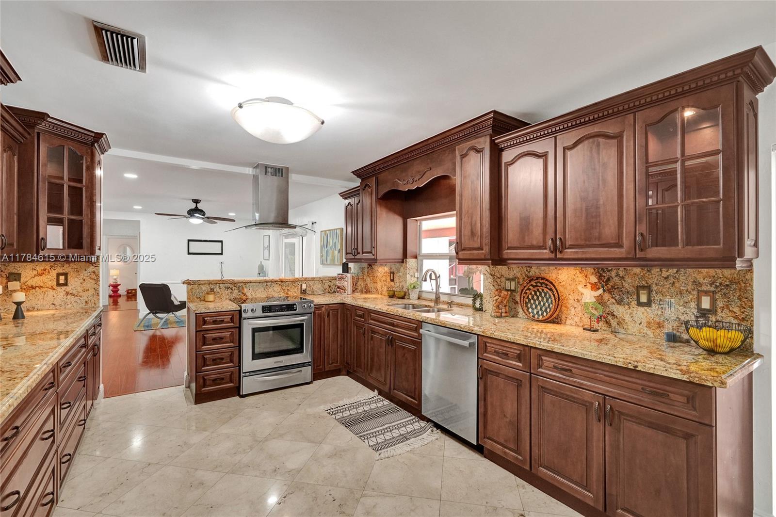 7360 Southwest 120th Street Pinecrest, FL 33156 - Photo 4 of 68 a kitchen with stainless steel appliances granite countertop a stove sink and cabinets