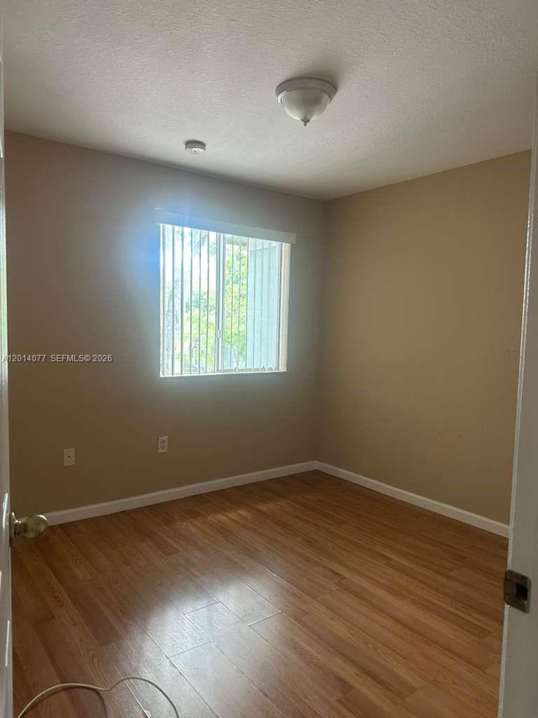 2913 Southeast 15th Road, Unit 64 Homestead, FL 33035 - Photo 11 of 14 an empty room with wooden floor and windows